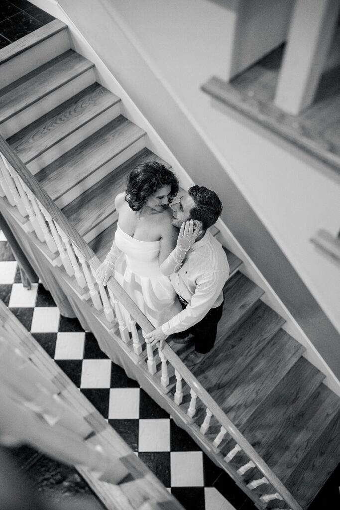 Fun-loving Fairview Inn Engagement Session in Mississippi by Lindsay Ott Photography.  Black & white photo with couple on staircase.